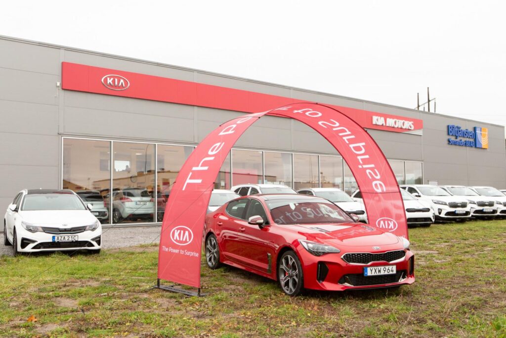 Event arch at Kia car dealer. Red car.